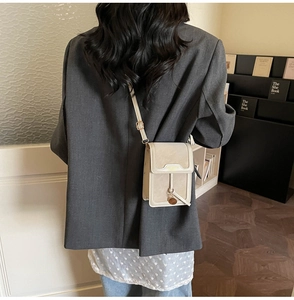 On-body shot of a minimalist beige mini crossbody phone bag with adjustable strap