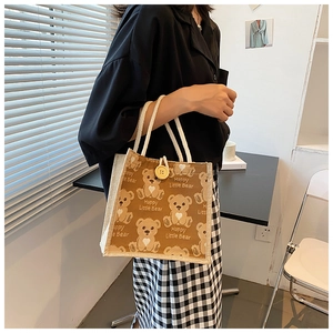 Close-up of linen tote bag with Happy Little Bear print, woven rope handle and button