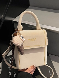 Chic cream vertical crossbody bag with gold studs, top handle and plush ice cream charm