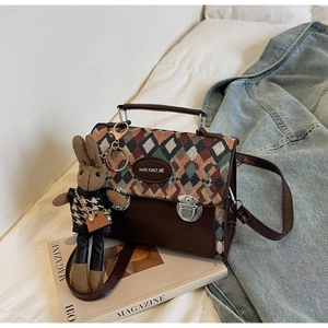 Détail du motif matelassé sur sac en cuir marron avec charmant lapin en peluche