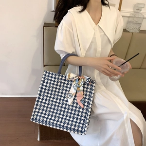 Detail of large navy houndstooth tote bag featuring a decorative silk scarf bow detail