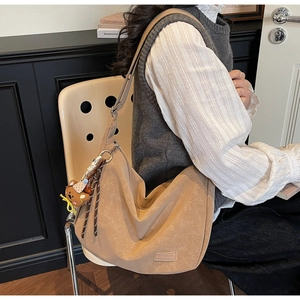 Détail du sac hobo camel montrant la texture rétro et le charmant pendentif ours