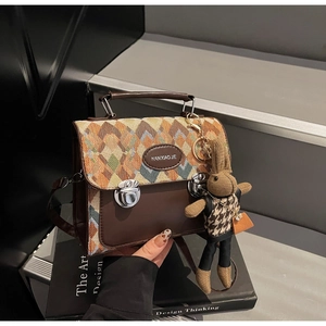 Détail du motif à losanges tissés et du cuir marron texturé sur ce sac à main de luxe