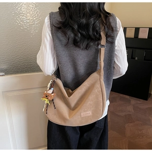 Détail du sac à main kaki avec pendentif d'ours et étiquette fashion en lumière douce
