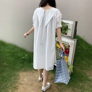 Detail of a large capacity blue plaid tote bag styled with a white A-line dress