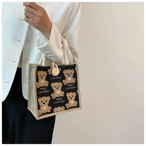 Detailed view of the cute bear canvas tote bag with yellow button and rope handles