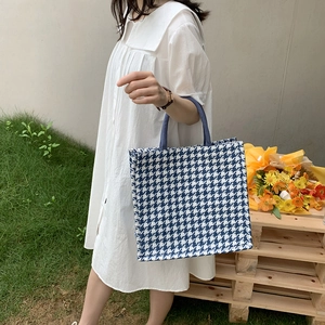 Blue houndstooth tote bag shown in a lifestyle scene with a white dress model