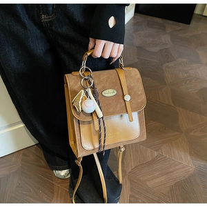 Detail van retro handtas in kleurblok-ontwerp met creatieve honkbal- en handschoen-bedel