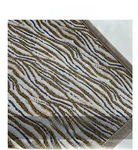 Macro shot of zebra pattern woven fabric with gold and silver threads and grey border