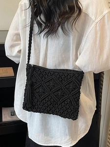 Handmade black woven crossbody straw bag with tassel and diamond pattern for beach vacations