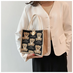 Détail du sac à déjeuner en toile avec motif ours et fermeture à bouton décoratif