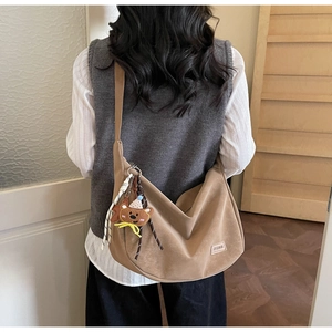 Vue détaillée du sac croissant kaki avec étiquette de mode et pendentif ours mignon