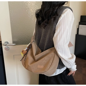 Gros plan du sac hobo kaki avec étiquette en cuir FASHION et pendentif ours mignon