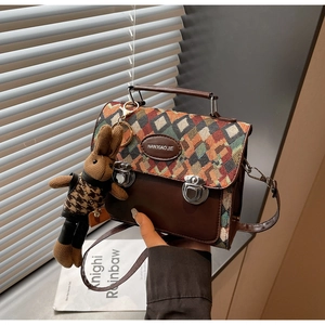 Détail du sac à rabat losange avec charm lapin en tricot et logo métallique