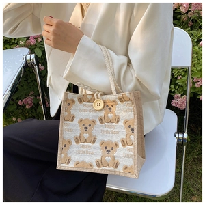 Linen tote bag detail with teddy bear print, cotton rope handle and wood button closure