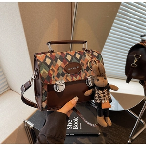 Détail du sac à motif losanges avec verrous en métal et un charmant pendentif lapin