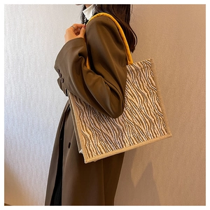 Detail of zebra pattern tote bag with yellow rope handle and thick fabric texture