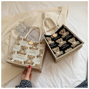 Detail of canvas mini bear bags with cotton rope handles and large wooden button closures
