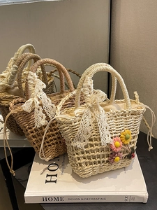Straw woven bucket bags with lace bows and drawstring lining in a stylish group display