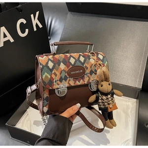 Détail du sac bandoulière matelassé en cuir marron avec un pendentif lapin mignon