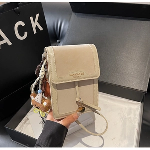 Detail of beige PU leather mini crossbody bag with cute plush bear pendant accessory