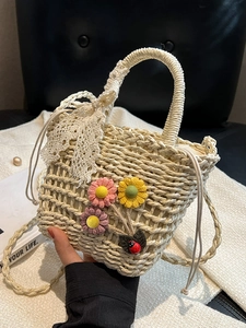 Handmade woven straw bucket bag with floral accents and lace bow for summer beach vacations