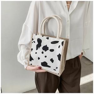 Detailed view of the cow print pattern and durable jute handle on the tote lunch bag