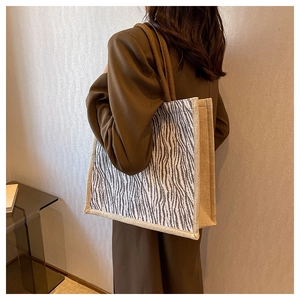 Detail of zebra print tote bag with thick rope handles and linen side panels