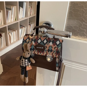 Détail du sac tissé vintage à motif géométrique avec bordure en cuir et lapin