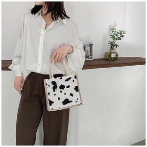 Detail of cow print canvas lunch bag with woven handles for daily outfit matching