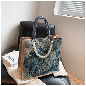 Detail view of floral jacquard fabric and linen panels on the large tote bag