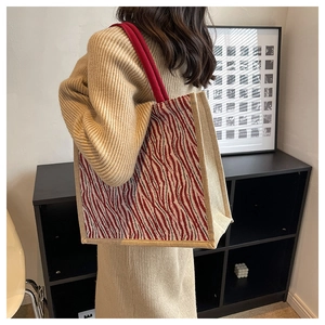 Detail of large linen tote bag with red zebra pattern and sturdy rope handles on shoulder