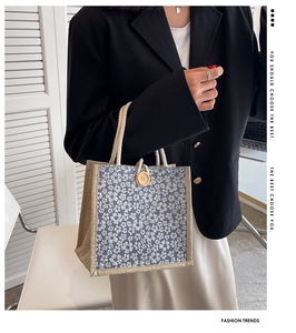 Detail of floral linen tote bag with wooden button and blue flower pattern