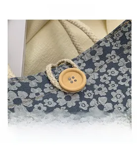 Close-up of grey-blue floral jacquard fabric with a wooden button and braided cord