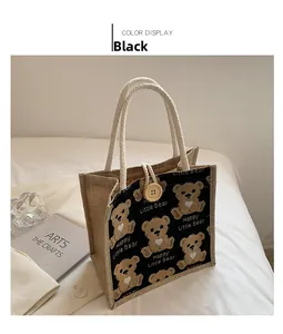 Detail of black linen tote bag featuring cute bear patterns and woven cotton handles
