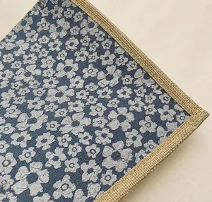 Detailed macro of floral jacquard fabric with woven hemp edges and cotton rope handle