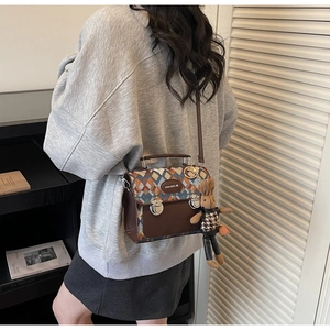 Détail du sac à bandoulière matelassé rétro avec doubles boucles et breloque lapin