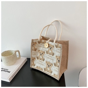 Detail of linen tote bag with cartoon bear print and yellow button closure