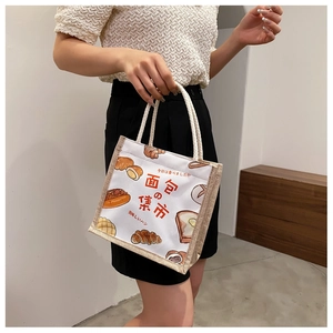 Detailed view of canvas tote bag with bread illustration and thick rope handles