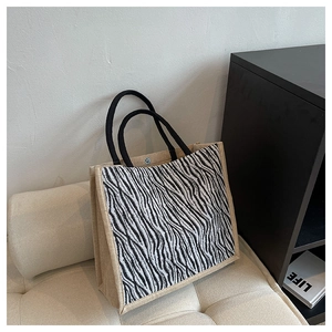 Detail of zebra print jute tote bag showing fabric texture and braided rope handles