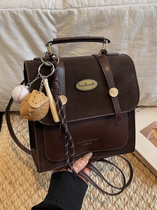 Vintage donkerbruine crossbodytas met handvat en sportieve tassenhanger accessoire