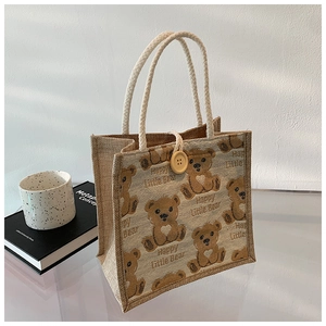 Detail of linen tote bag with brown bear prints, rope handle and wooden button closure