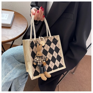 Detail of linen tote bag featuring argyle pattern and cute rabbit plush pendant accessory