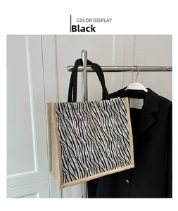 Detail of zebra print tote bag with natural jute trim and sturdy black top handles