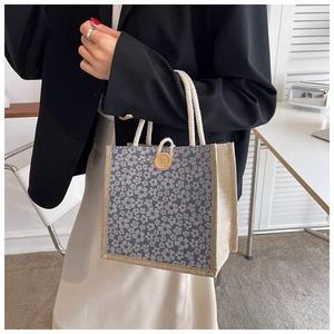 Detail of floral linen tote bag with white cotton rope handles and wooden button closure
