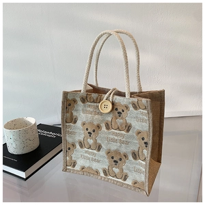 Detailed macro of jute tote bag with bear print, cotton rope handles and wood button
