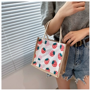 Close-up of mini canvas tote bag with strawberry print and thick rope handles