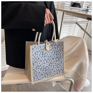 Detail of blue floral linen tote bag with retro wooden button and rustic handle