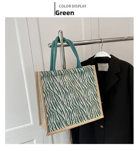 Detail of green and white zebra pattern woven tote bag with brown linen trim and rope handles