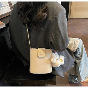 Détail du sac seau blanc cassé avec un charmant alpaga en peluche et une boucle ronde